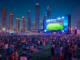 Public Viewing in Dubai. Umrandet von Hochhäusern steht eine Leinwand und eine Menschenmenge guckt begeistert zu